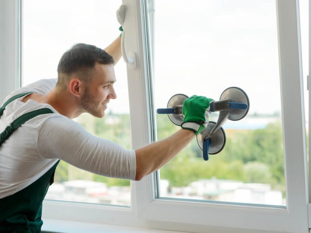 Man lifting glass with suction tool